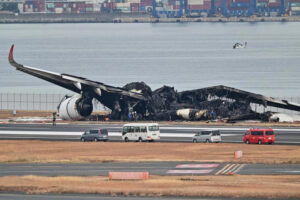 Officials look at the burnt wreckage of a Japan Airlines passenger plane on the tarmac at Tokyo International Airport at Haneda in Tokyo on January 3, 2024. LivemintUSA